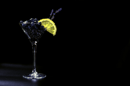 Cocktail with bluberriy in martini glass isolated on black backgroundの写真素材