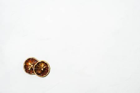 Two brown dryed orange small slice on a white marmor backgroundの写真素材