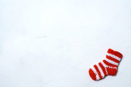 Christmas sock in a white-red strip on a white marmor backgroundの写真素材