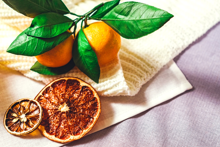Romantic winter and New Year's interior view with a tangerine on white sweaterの写真素材
