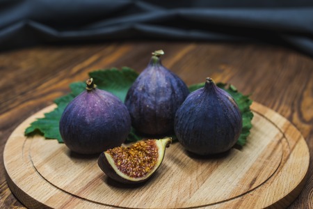 A few vivid cuted figs on a plate on an old wooden backgroundの写真素材