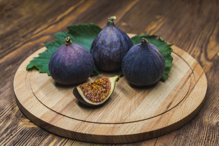 A few vivid cuted figs on a plate on an old wooden backgroundの写真素材