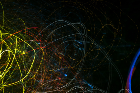 Bright abstract spiral patterns from colored light strips on a black backgroundの写真素材