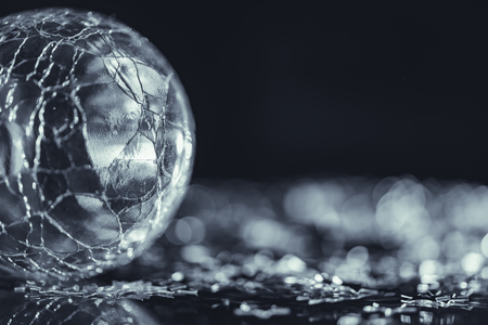 Macro photo of cracked glass sphere silver star with light bokehの写真素材