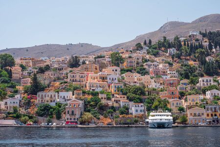View of the coast of Symi island with multicolored houses in summer day, Greece, Europeのeditorial素材