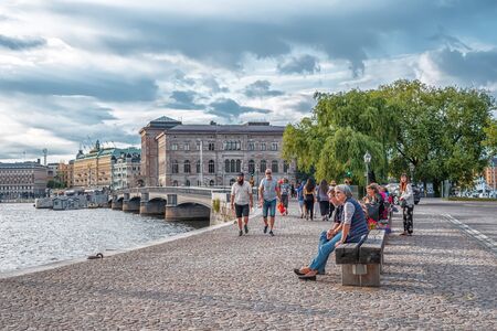 STOCKHOLM/SWEDEN - AUGUST 2, 2019: View on coastline of Skeppsholmen island with people on the benchesのeditorial素材