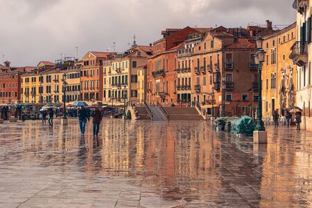 Venice/Italy - April 28, 2017: Embankment street with houses and tourists with umbrellas in the rainy dayのeditorial素材