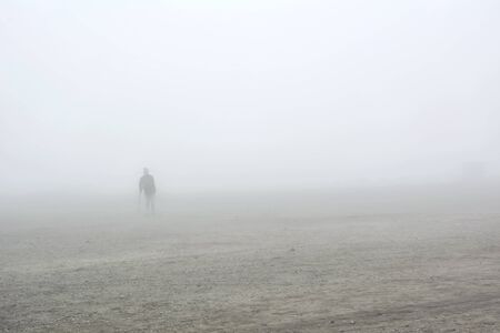 Nordkapp, Norway - 26 July, 2017: Lonely tourist with a crutch on a fog and misty land at the top of Nordkappのeditorial素材