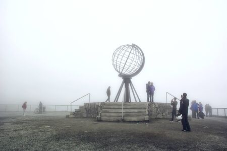 Nordkapp, Norway - 26 July, 2017: Nordkapp edge cliffhanger with the globus monument with tourist around in summer foggy day. Nord cape, Finnmark, Mageroya island.のeditorial素材
