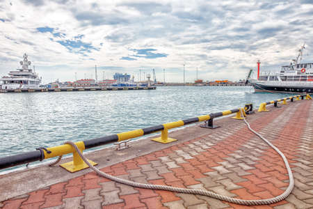 Sochi, Russia - June 13, 2019: Port of Sochi view on red brick coastline with rope