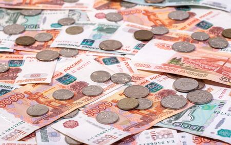 Background of banknotes of rubles laying on a surface with the lot of coinsの写真素材