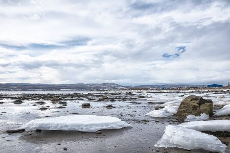 Pieces of freshwater ice at in the water near coast in early springの写真素材