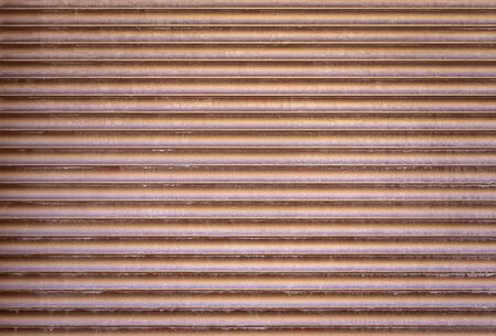 Brown metallic roller shutter door garage door parallel backgroundの写真素材