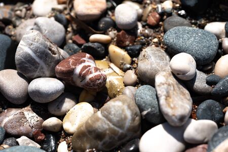 Colour different stones and pebbles on the seaside sand