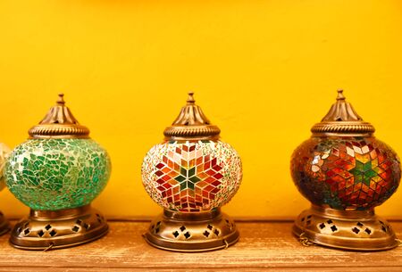 Oriental turkish lanterns at the street market on a yellow wall backgroundの写真素材
