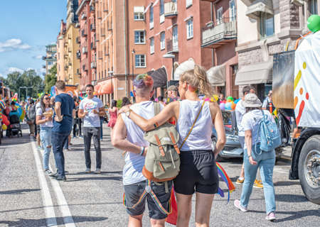 Stockholm, Sweden - August 2, 2019: People on the street prepairing to a Pride parade. Two girls hug...