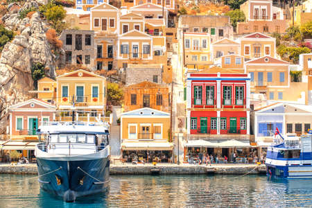 Symi, Greece - June 27, 2019: View of the coast of Symi island with town with multicolored houses,...