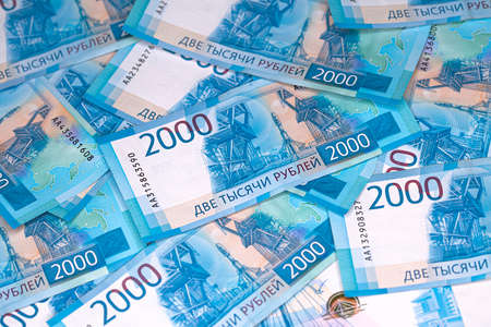 Background of banknotes of two thousand Russian rubles in a blue design laying on a surfaceの写真素材