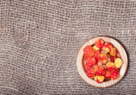 Fresh cloudberries prepared for food against the background of a rough village hessian bag