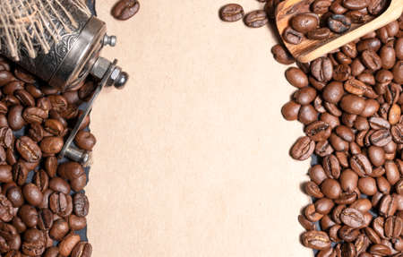 Fresh roasted coffee beans flat background with coffee grinder and free space for textの写真素材