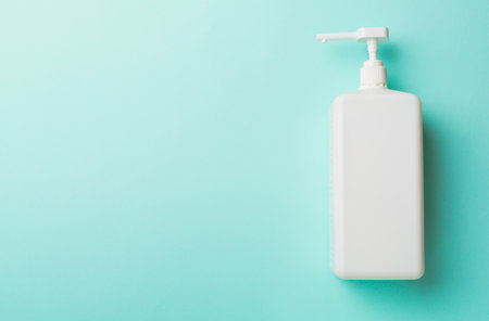 Hand sanitizer in white bottle on color background.