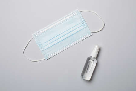 Medical mask and hand sanitizer on color background. Top view, flat lay.の写真素材