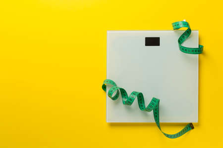 Scales and measuring tape on color background, top view. weight loss concept.の写真素材