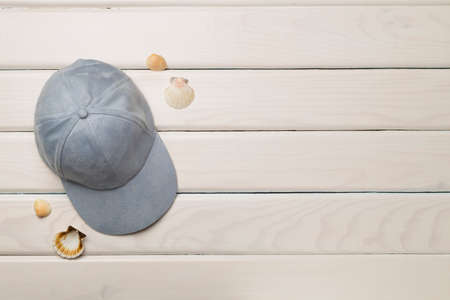 Blue cap and seashells on wooden background, top view.の写真素材