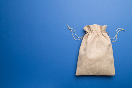 Burlap eco sack on color background, top view.