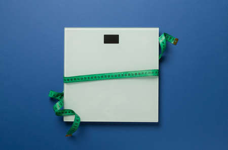 Scales and measuring tape on color background, top view. weight loss concept.の写真素材