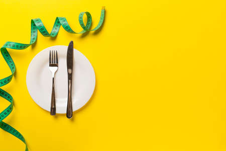 Green tape measure with plate on color background, top view.の写真素材