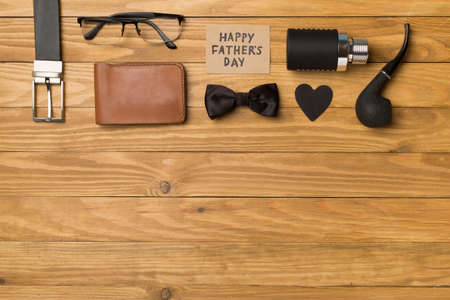 Happy Father's Day inscription with different gifts on wooden background, top view.の写真素材
