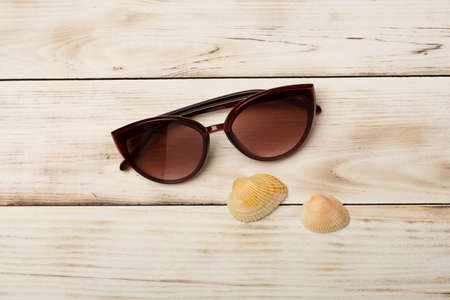 Sunglasses and seashells on color background, top view.の写真素材