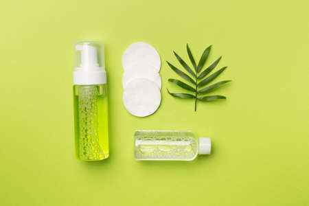 Foaming facial cleanser and micellar water on color background, top view.の写真素材