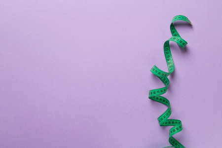 Green measuring tape on color background, top view.の写真素材