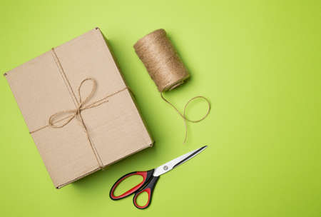 Box, rope and scissors on color background.の写真素材