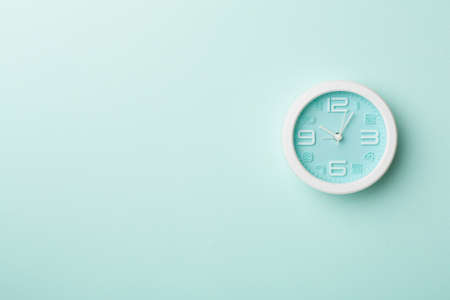 Blue clock on color background, top view.の写真素材
