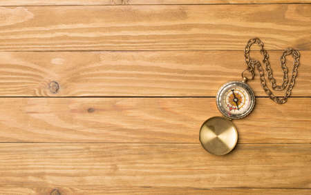 Old vintage compass on wooden background. Top view.の写真素材