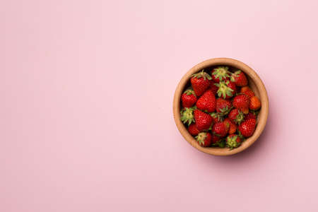 Bowl with fresh strawberries on color background, top view.の写真素材