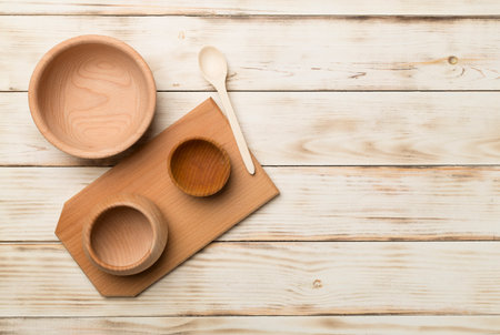 Wooden bowls and board on wooden background, top view.の写真素材