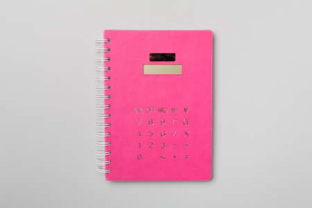 Pink notebook-calculator on color background, top view.の写真素材