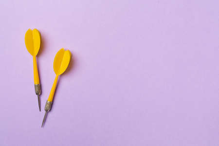 Yellow darts on color background, top view.の写真素材