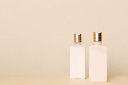 Bottles of cosmetic products on table background against light wall.の写真素材