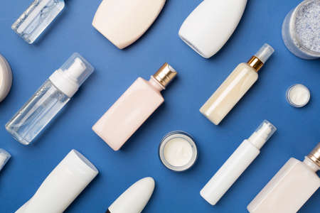 Different cosmetic bottles and container on color background, top view.の写真素材