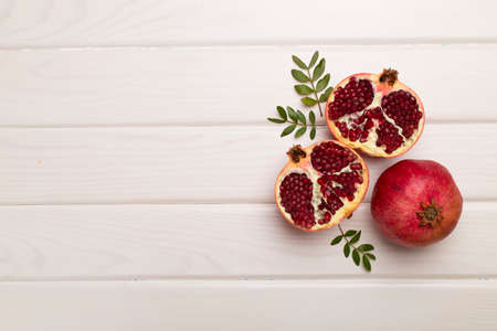 Fresh juicy pomegranate on white wooden background, top view.の写真素材