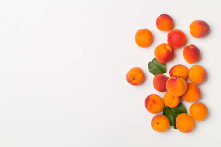 Flat lay with ripe apricots on white background, top view.