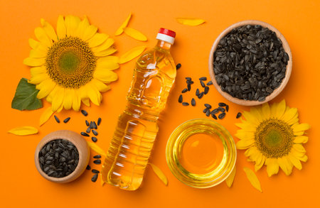 Sunflower oil, seeds and flower on color background.の写真素材