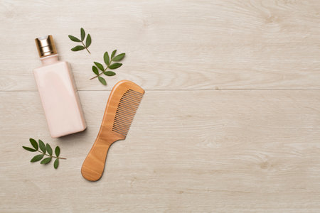 Shampoo with herbal extract and comb on wooden background, top view.の写真素材