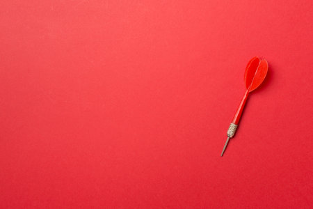 Red dart on color backgroundm top view,