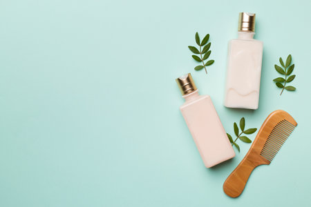 Shampoo and conditioner with herbal extract and comb on color background, top view.の写真素材